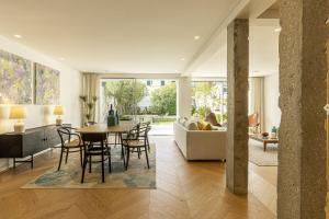 una sala da pranzo e un soggiorno con tavolo e sedie di Contemporary Restelo Pool Haven a Lisbona