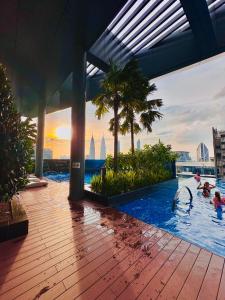 a pool on the top of a building with people in it at Eaton Suites KL By Luna in Kuala Lumpur