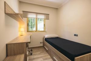 Un dormitorio con una cama y un escritorio y una ventana. en Oasis Salou, en Salou 29 fotos más