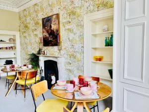 a dining room with two tables and a fireplace at Scot Townhouse in Edinburgh