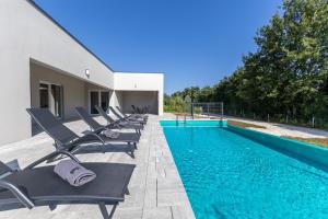 a row of chairs sitting next to a swimming pool at E&M Forest Retreat in Svetvinčenat