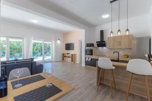 a kitchen and living room with a table and chairs at E&M Forest Retreat in Svetvinčenat