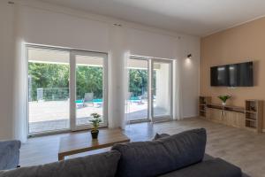 a living room with a couch and a flat screen tv at E&M Forest Retreat in Svetvinčenat
