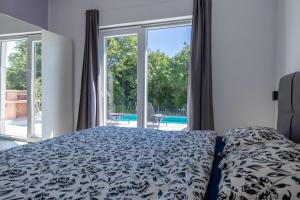 a bedroom with a bed and a large window at E&M Forest Retreat in Svetvinčenat +27 photos