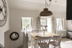 a dining room with a table and chairs at Shepherds Cottage, Pentland Hills in Nine Mile Burn