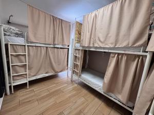 a room with bunk beds with curtains and a wooden floor at Orange Terrace Hostel in Albufeira +12 photos