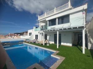 ein weißes Haus mit einem Swimmingpool davor in der Unterkunft Villa Las Vistas Costa Adeje in Callao Salvaje