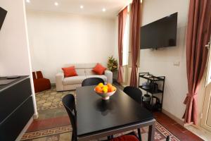 a living room with a table with a bowl of fruit on it at Appartamenti centro città Downtown Aitne in Catania