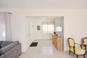 a living room with a couch and a table and chairs at Seraina House in Pastida
