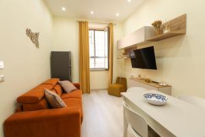 a living room with a couch and a table at Appartamenti centro città Downtown Aitne in Catania