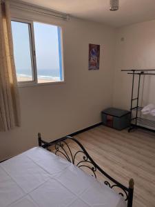 a bedroom with a bed and two windows at Eco Stay by Ocean Sea View Apartment near Souss Massa National Park in Rbat