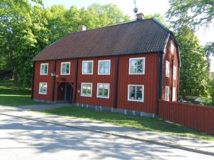 a red barn with a black roof at SB Mangelgården in Söderköping