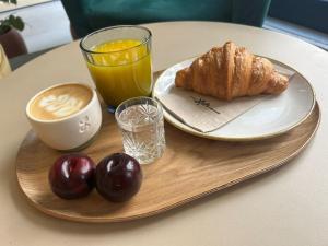 un plateau de petit-déjeuner avec une tasse de café, un croissant et un jus d'orange dans l'établissement The Loft House Madrid, à Madrid