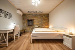 a bedroom with a bed and a stone wall at Istrska kamnita hiša z velikim vrtom - Istrian Stone House with Big Garden in Marezige