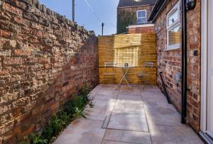 a brick wall with a table in a courtyard at 4 bedroom house close to Walmgate bar sleeps 7 in York