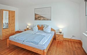 a bedroom with a bed with blue sheets and two lamps at Ferienwohnung Ankershagen in Friedrichsfeld
