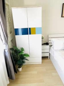 a bedroom with a white bed and a colorful cabinet at Xin Hostel Wachiratham 21 in Amphoe Phra Khanong