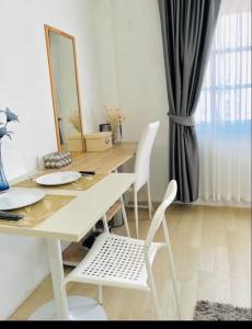 a table with two white chairs and a mirror at Xin Hostel Wachiratham 21 in Amphoe Phra Khanong