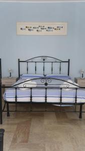 a bed with a black frame and blue sheets at BB Gallipolis Terra in Gallipoli +50 photos
