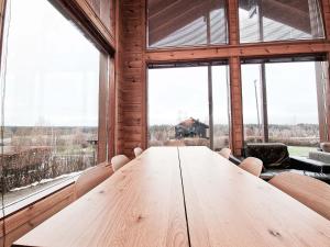 einen Holztisch in einem Zimmer mit großen Fenstern in der Unterkunft Villa Lumikki 2 - 8 hlö, Luoteis-Himos Ski-inout in Jämsä + 14 Fotos