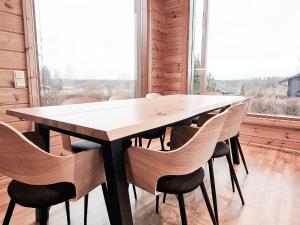einen Holztisch und Stühle in einem Zimmer mit Fenster in der Unterkunft Villa Lumikki 2 - 8 hlö, Luoteis-Himos Ski-inout in Jämsä