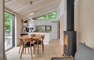 a kitchen and dining room with a wood stove at Holiday Home Højdevej in Vejby