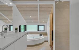 a bathroom with a tub and a sink at Holiday Home Højdevej in Vejby +10 photos