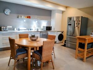 a kitchen with a table and chairs and a refrigerator at l'Isle Contemporaine Centre ville de L'Isle sur la sorgue 74 m2 clim parking in LʼIsle-sur-la-Sorgue