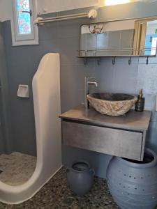 a bathroom with a bowl sink and a toilet at OrkiSEA-Orkos beach in Mikri Vigla