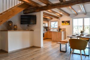 a living room with a table and a tv on a wall at Waldfrieder Ferienwohnungen in Lauterbach