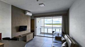 a living room with a couch and a large window at Quarto em Praias do Lago Resort in Caldas Novas