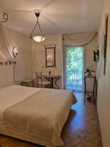 a bedroom with a bed and a table and a window at Logis Hôtel Restaurant Les Norias in Cazilhac