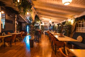 a restaurant with tables and chairs and plants at Casa Vatra Radauti in Rădăuţi