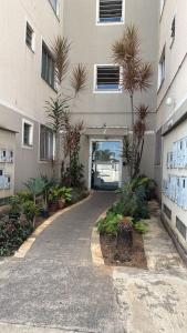 a building with a courtyard with palm trees in front of it at Apto 2 quarto Completo com Vaga in Contagem