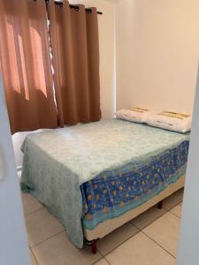 a small bed in a room with a window at Apto 2 quarto Completo com Vaga in Contagem +2 photos