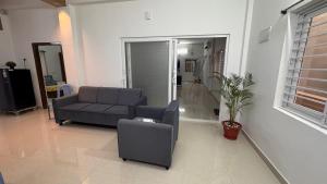una sala de estar con un sofá y una silla en Ravula's Stay, en Hanamkonda