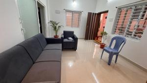 una sala de estar con un sofá y dos sillas en Ravula's Stay, en Hanamkonda