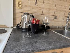 two wine glasses sitting on a counter next to a sink at Centar Sweet Home in Šabac