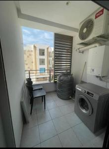 a laundry room with a washing machine and a window at Appartement à Khezama Est Sousse in Hammam Sousse