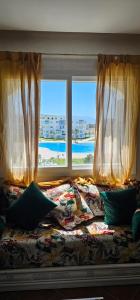 a bed in a room with a large window at Superbe apartment en residence with pool in Cabo Negro
