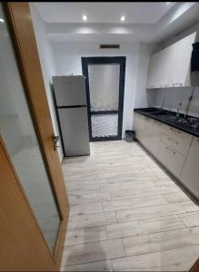 a kitchen with white cabinets and a floor with a refrigerator at Appartement à Khezama Est Sousse in Hammam Sousse +7 photos
