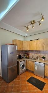 a kitchen with a stainless steel refrigerator and a dishwasher at Superbe apartment en residence with pool in Cabo Negro +6 photos