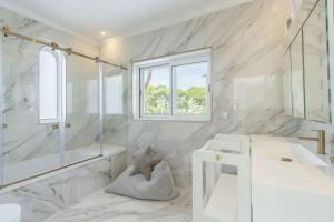 a white bathroom with a shower and a sink at Vale Do Lobo Resort in Vale do Lobo