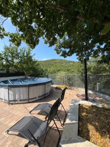 a patio with two chairs and a swimming pool at Kuća za odmor Krasnica in Novi Vinodolski