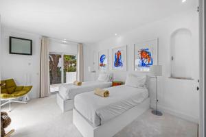 a white bedroom with two beds and a chair at Vale Do Lobo Resort in Vale do Lobo +37 photos