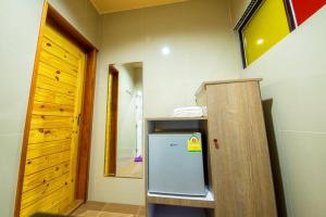 a kitchen with a small refrigerator in a room at Thansila Resort&Garden Buriram in Buriram