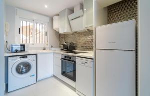 a kitchen with a washer and dryer and a refrigerator at Amazing Apartment In Oropesa Del Mar in Oropesa del Mar