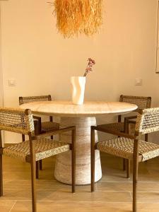 a table with chairs and a vase with flowers on it at MiradorEnPorter - Nuevo - Vistas Increibles in Cala'n Porter