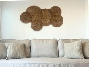 a couch with three wooden flowers on a white wall at MiradorEnPorter - Nuevo - Vistas Increibles in Cala'n Porter +24 photos