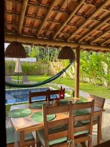 a table with chairs and a hammock in a backyard at CASA RENASCER in Trancoso +12 photos